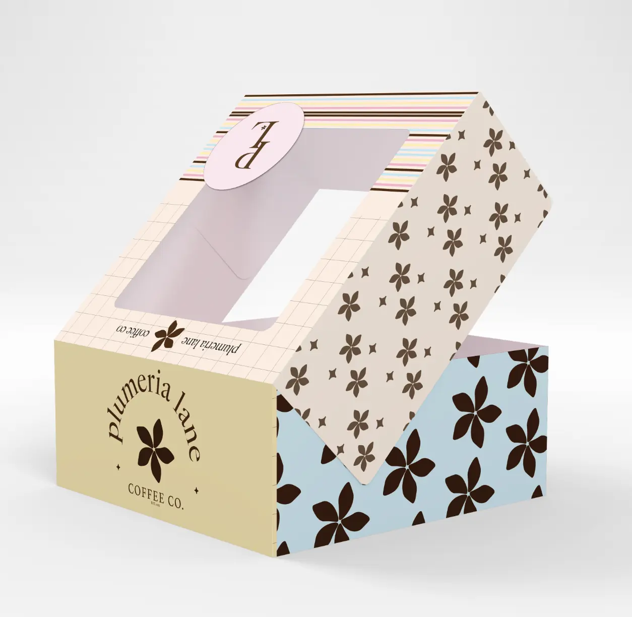 Open Plumeria Lane pastry box with blue, yellow, blush, and floral packaging details