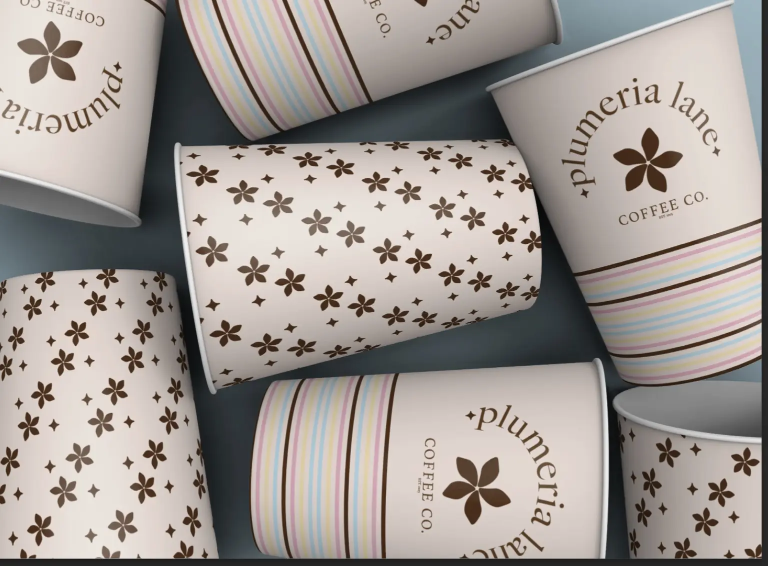 Plumeria Lane coffee cups with floral patterns, pastel stripes, and curved logo typography