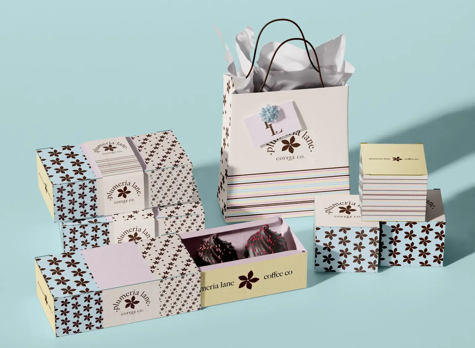 Plumeria Lane cafe packaging collection with patterned pastry boxes, shopping bag, and small cartons